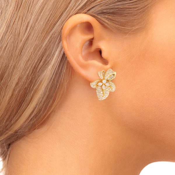 Aretes estilizados motivo flor con diamantes en oro amarillo 18 kilates. Online now