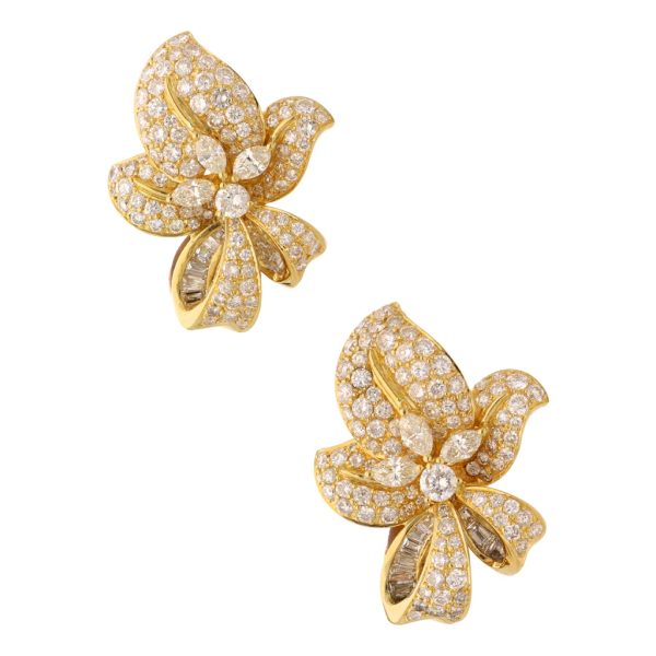 Aretes estilizados motivo flor con diamantes en oro amarillo 18 kilates. Online now